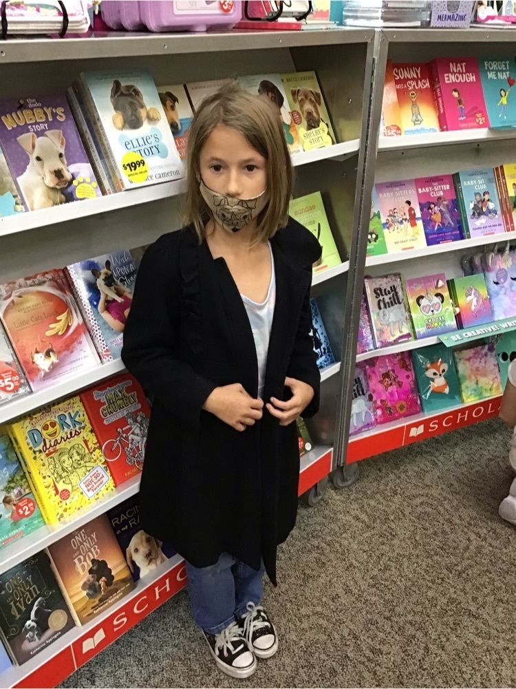 Girl in front of Book Fair cart.